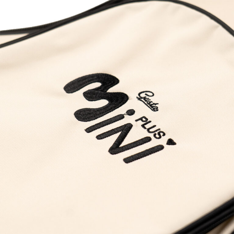Close-up of beige fabric bag with a black logo reading 'MINI' and small cursive brand name. ขายราคาพิเศษ