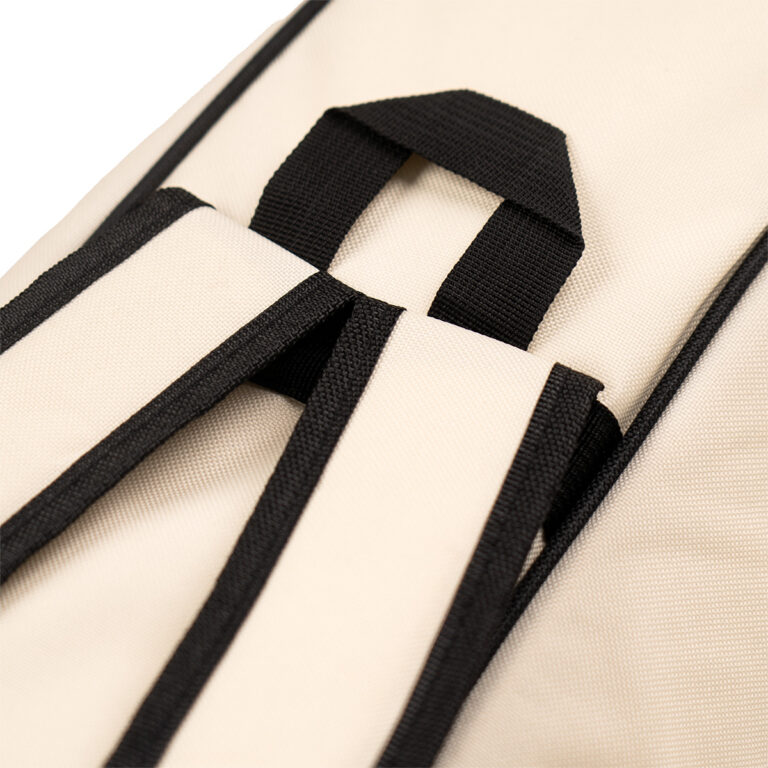 Close-up of a beige fabric bag showing black webbing straps and loops detail. ขายราคาพิเศษ