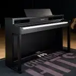 Black upright piano with three pedals on a dark rug in a music room; brand Samick visible on the fallboard. ขายราคาพิเศษ
