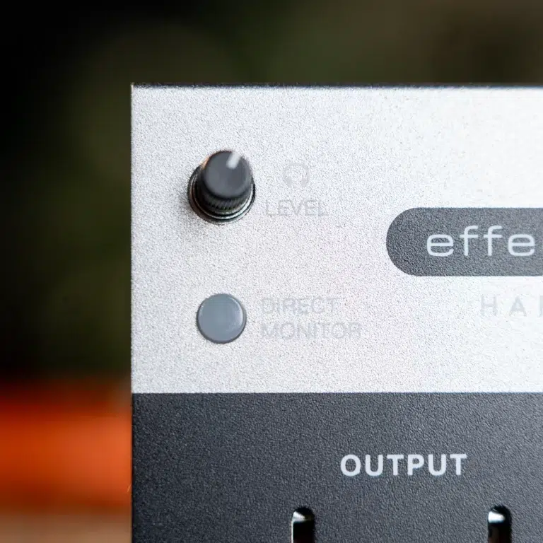 Close-up of a metal audio device front panel with a black level knob, a gray Direct Monitor button, and the word OUTPUT visible in bold. ขายราคาพิเศษ