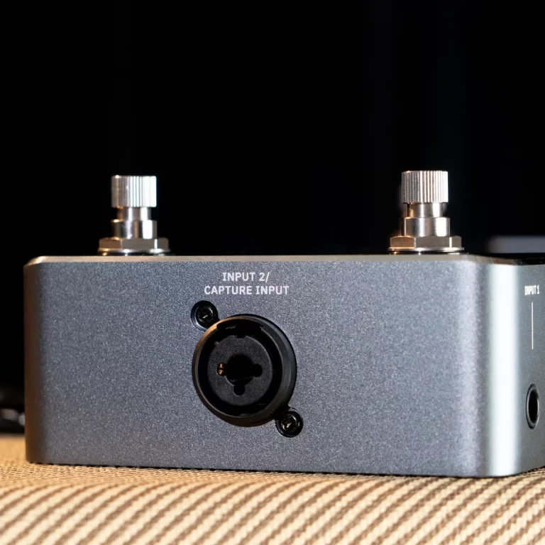 Front view of a gray audio interface showing an XLR input labeled 'Input 2 / Capture Input' and two metal knobs on top against a dark background. ขายราคาพิเศษ