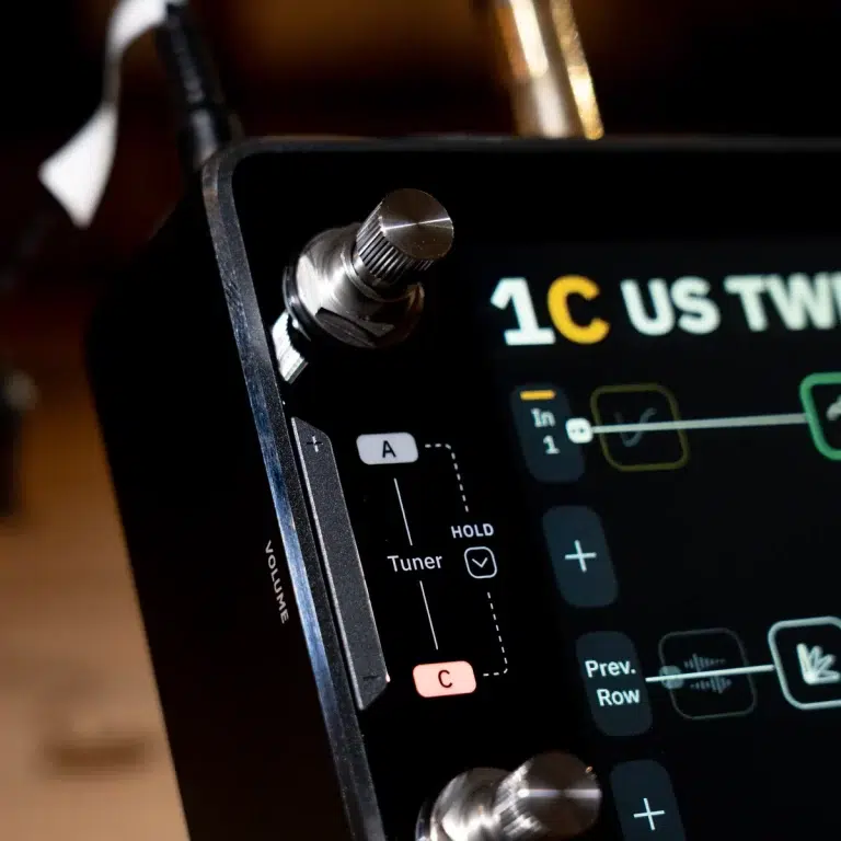 Close-up of a car stereo touchscreen showing tuner controls and volume knob on a metallic panel. ขายราคาพิเศษ