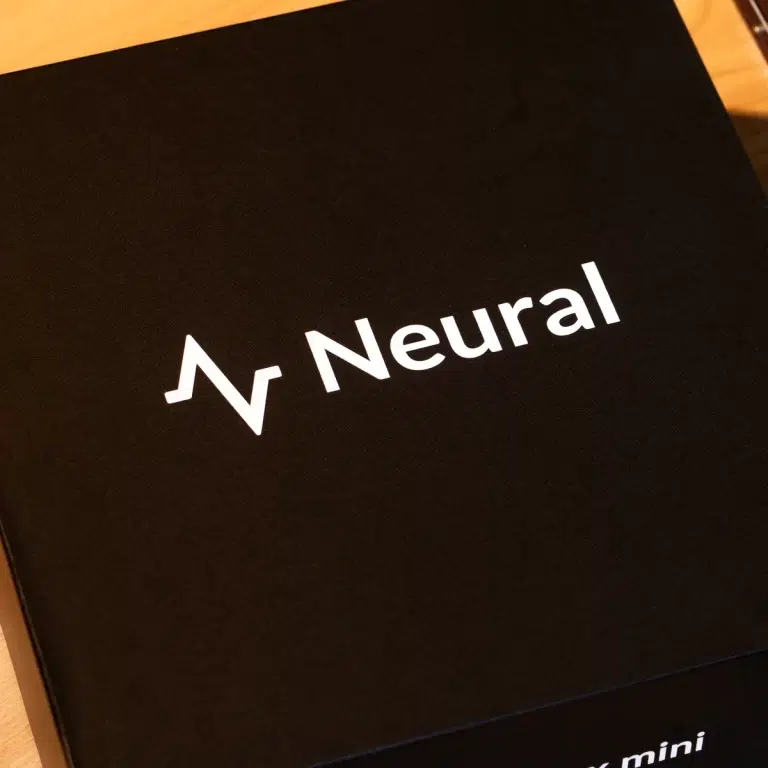 Black packaging box with a white 'Neural' logo and a zigzag symbol on a dark surface, likely product packaging. ขายราคาพิเศษ