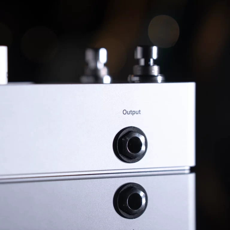 Close-up of silver audio device with an 'Output' jack, two circular ports visible on the front panel. ขายราคาพิเศษ
