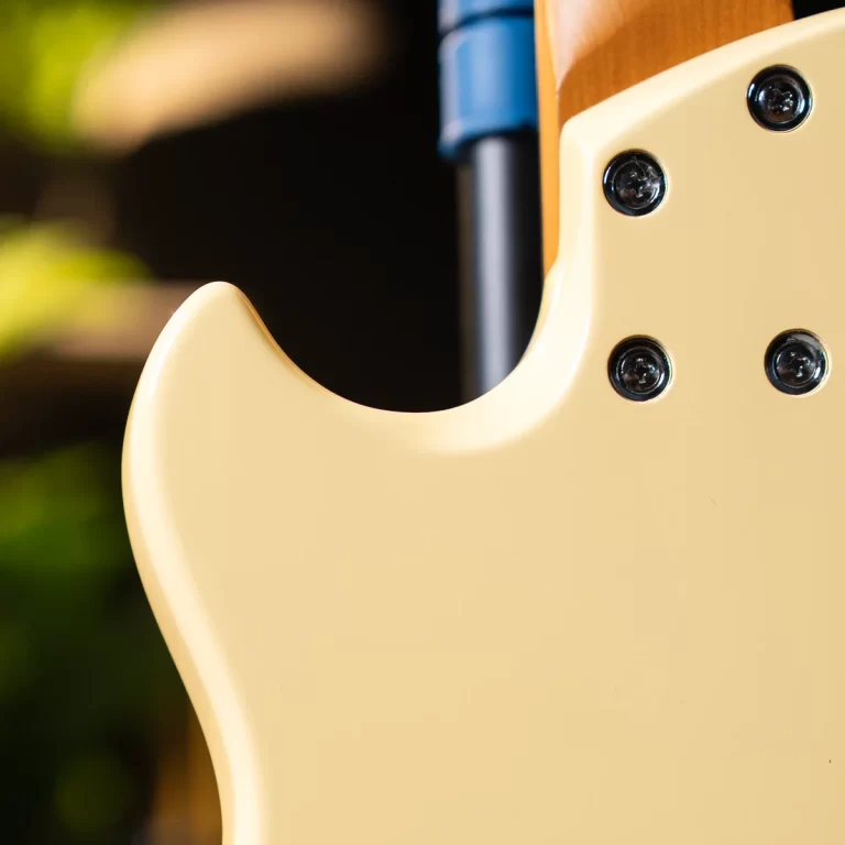 Close-up of a cream-colored electric guitar body showing the cutaway and neck plate screws. ขายราคาพิเศษ