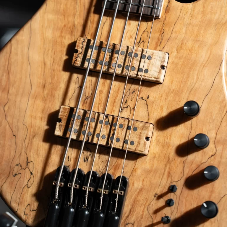 Close-up of a natural wood electric guitar showing two pickups, strings, and control knobs. ขายราคาพิเศษ