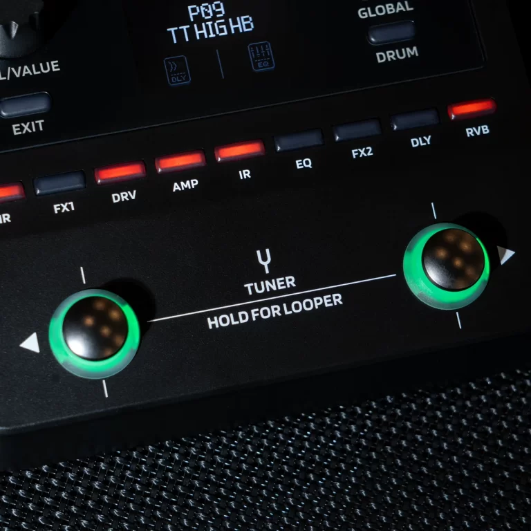Close-up of a guitar effects unit showing two green-ringed knobs and a row of red/blue status buttons labeled DRV, AMP, IR, EQ, FX2, DLY, RVB; text reads 'TUNER HOLD FOR LOOPER' in the center. ขายราคาพิเศษ