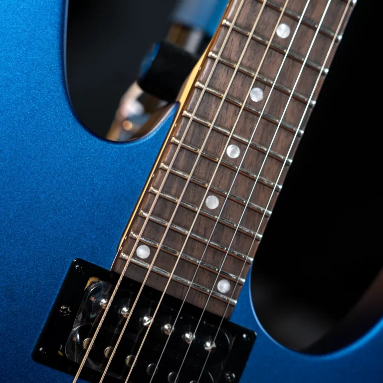 Close-up of a blue electric guitar neck with frets, inlays, and strings over a black pickup. ขายราคาพิเศษ