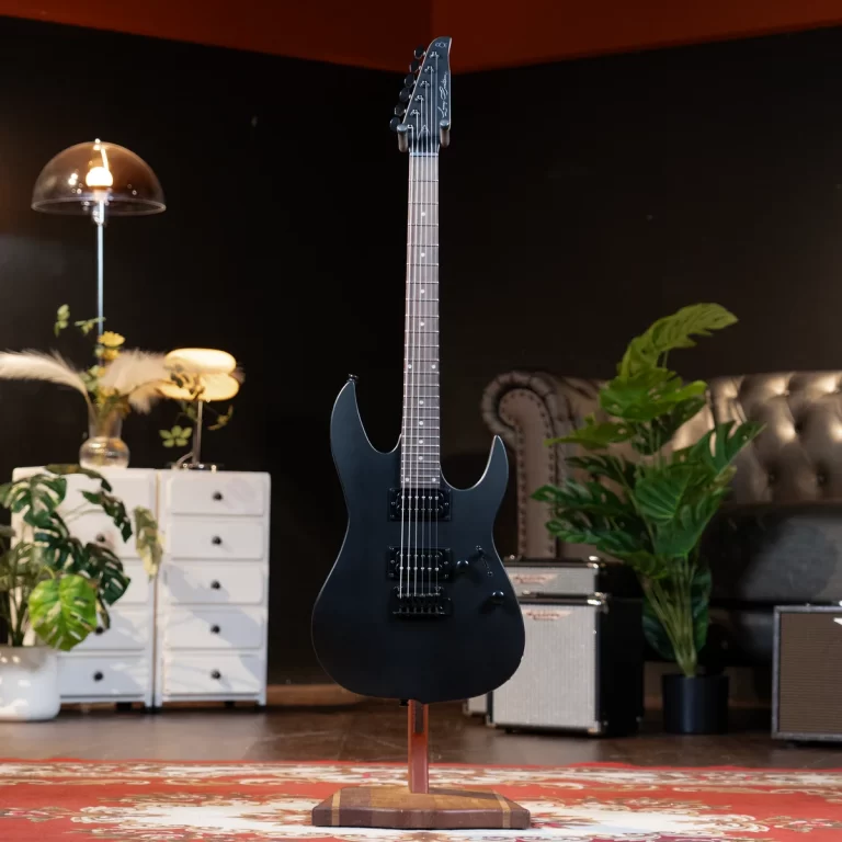 Black solid-body electric guitar on a stand in a cozy studio with plants, amp, and a rug backdrop. ขายราคาพิเศษ