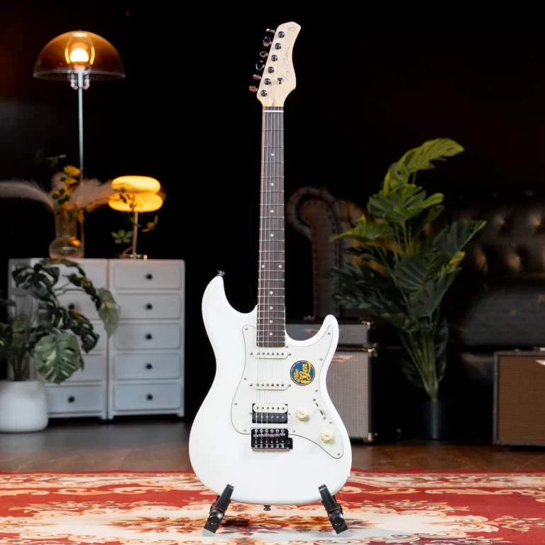 White electric guitar on a stand in a cozy studio space with plants, a rug, and vintage furniture in the background ขายราคาพิเศษ