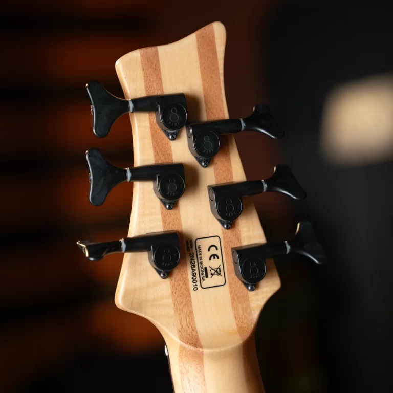 Back view of a natural wood guitar headstock with six black tuning pegs and a striped maple veneer detail ขายราคาพิเศษ