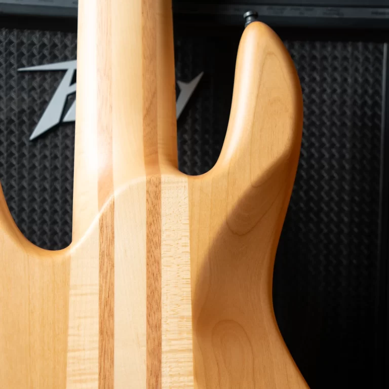 Close-up of a natural wood electric guitar body with a double-cutaway design and visible grain. ขายราคาพิเศษ