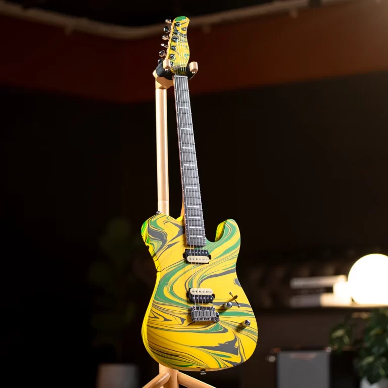Electric guitar with a yellow, green, and black swirl finish on a stand in a dimly lit stage-like setting. ขายราคาพิเศษ