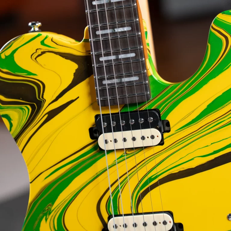 Electric guitar with a yellow-green marble finish, close-up on the neck, strings, and pickups. ขายราคาพิเศษ