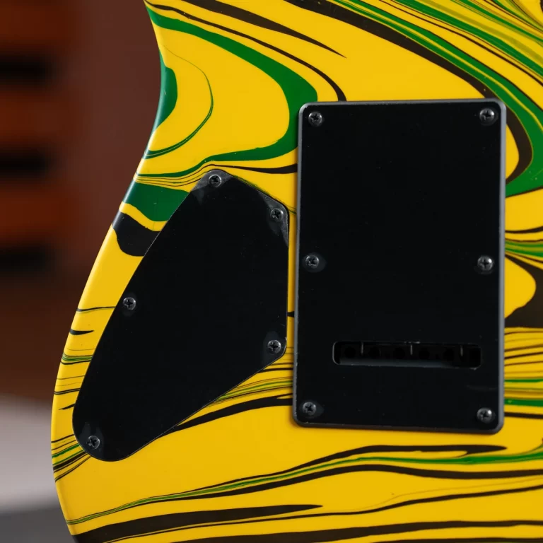 Close-up of a yellow guitar body with green and black marbled stripes, showing two black backplates and screws on the body. ขายราคาพิเศษ