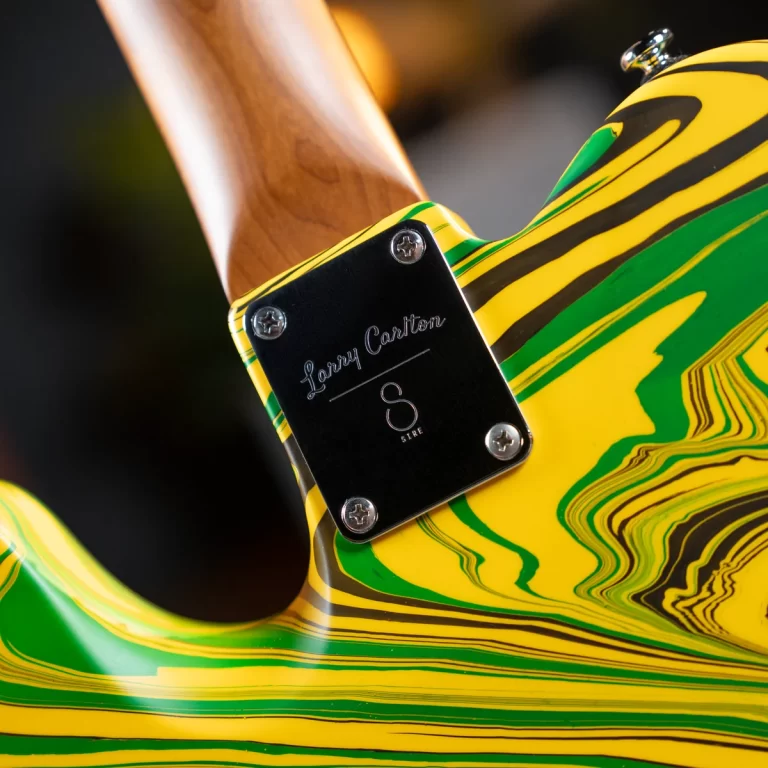 Close-up of a guitar neck plate on a yellow-green marbled body, engraved with 'Larry Carter'. ขายราคาพิเศษ