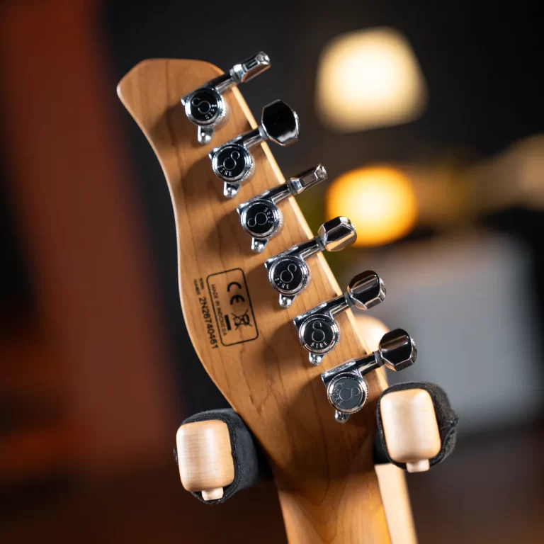 Close-up of a guitar headstock with six chrome tuning pegs on a wooden neck. ขายราคาพิเศษ