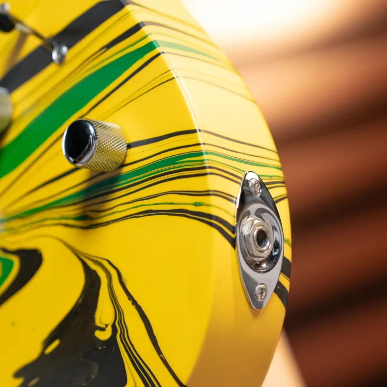 Close-up of a yellow striped guitar body with chrome knob and input jack plate. ขายราคาพิเศษ