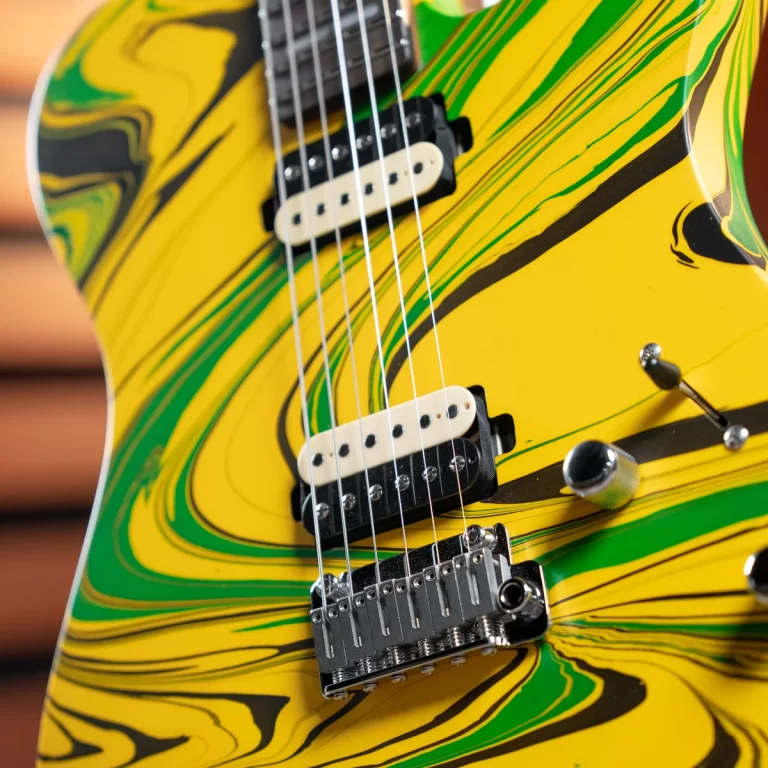 Close-up of a vibrant yellow-and-green swirl electric guitar showing pickups and a chrome bridge. ขายราคาพิเศษ