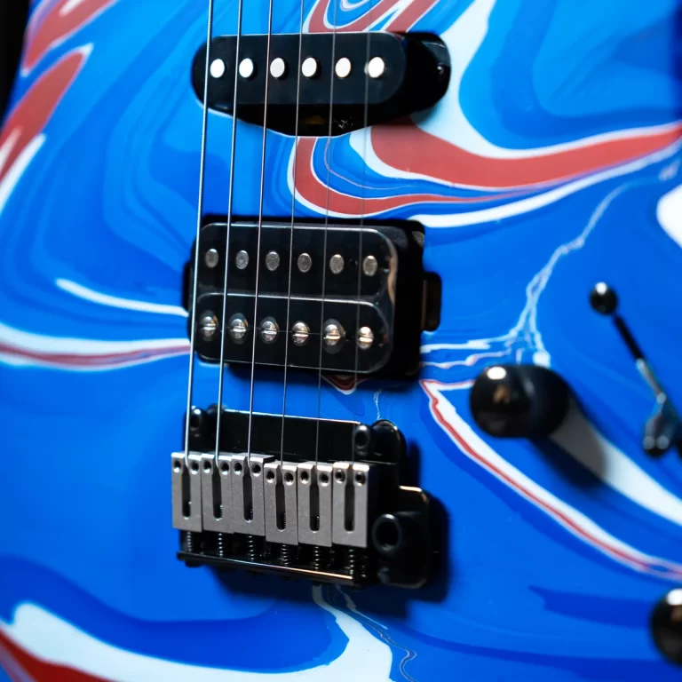 Electric blue electric guitar with red-white swirl art, close-up of pickups and bridge. ขายราคาพิเศษ