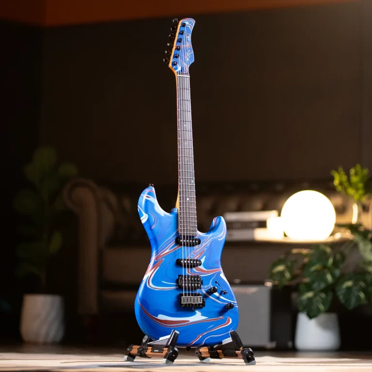 Blue marbled electric guitar on a stand in a cozy living-room setting with warm lamp light behind it. ขายราคาพิเศษ