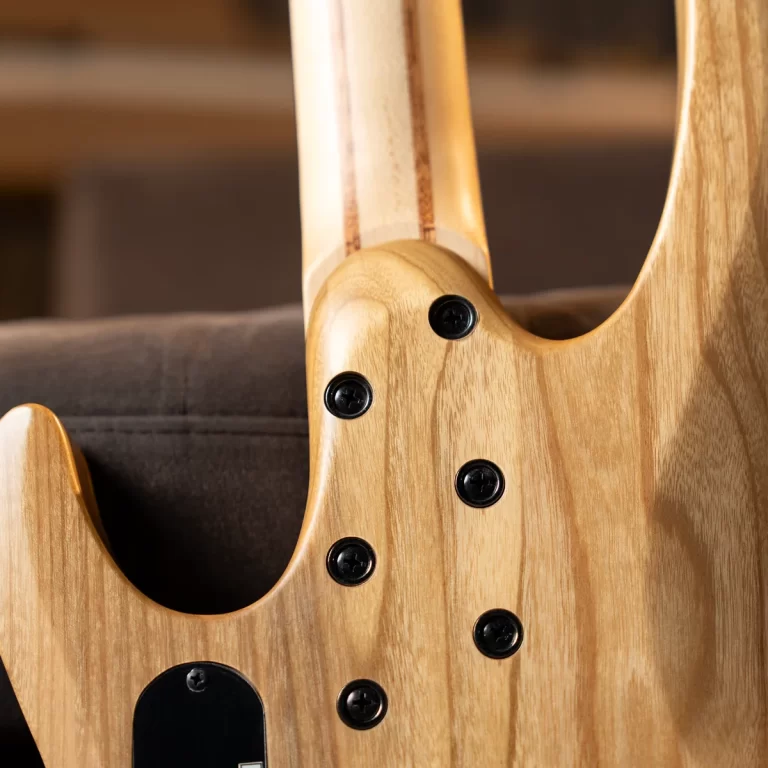 Back view of a natural-wood electric guitar with a bolt-on neck joint and multiple black screws showing the seam and grain pattern ขายราคาพิเศษ