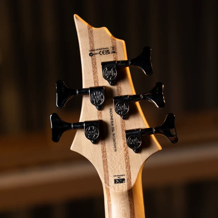 Close-up of a guitar headstock with six black tuners on a natural wood neck. ขายราคาพิเศษ