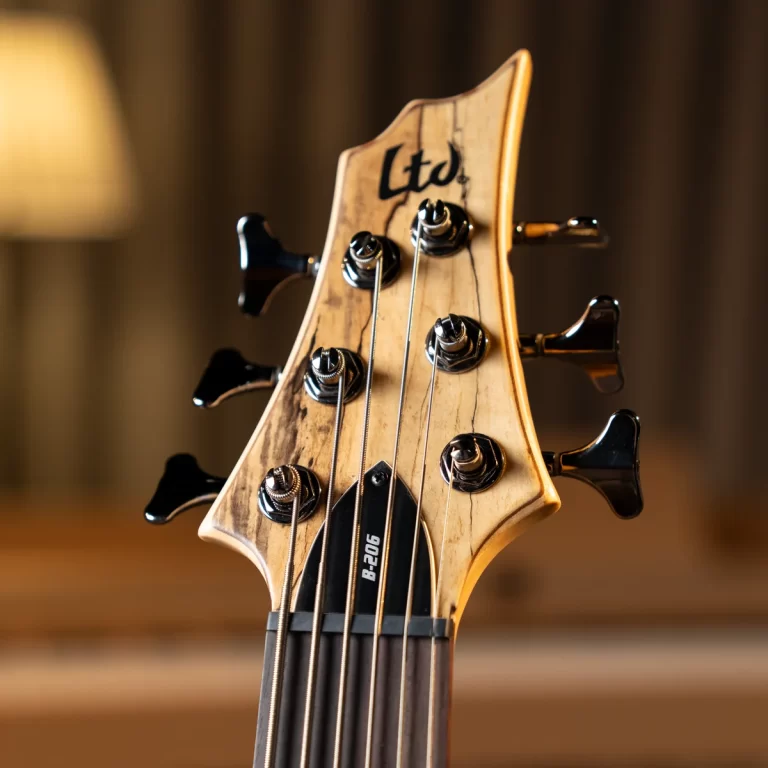 Close-up of a guitar headstock with six tuning pegs, strings, and a beige wood finish, LTD logo visible ขายราคาพิเศษ
