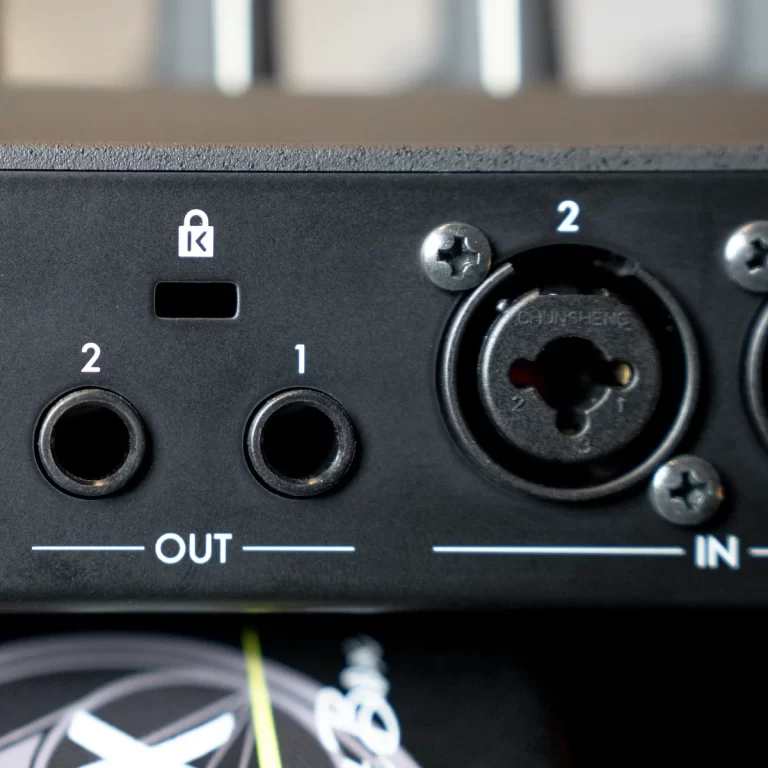 Close-up of a black audio interface rear panel showing two jacks labeled OUT and IN with a circular XLR-style connector nearby. ขายราคาพิเศษ