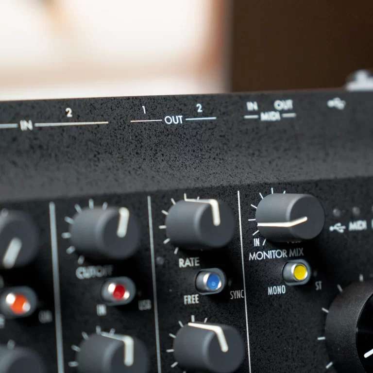 Close-up of a black audio mixer panel with knobs and labels like IN, OUT, MIDI, and MONITOR MIX. ขายราคาพิเศษ