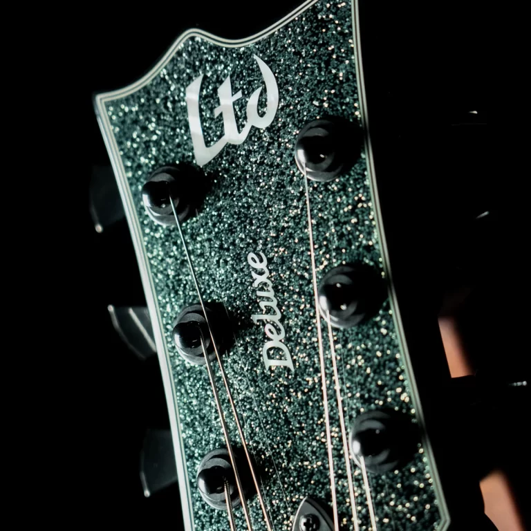 Close-up of a glittery green LTD guitar headstock with six tuning pegs visible ขายราคาพิเศษ