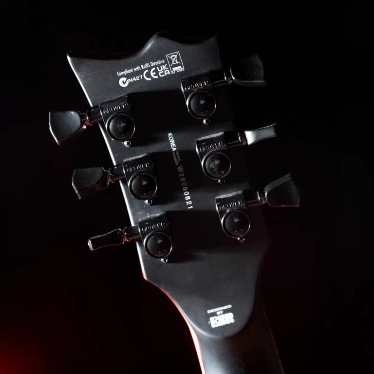 Guitar headstock with six Grover tuning pegs, dark background and red edge lighting. ขายราคาพิเศษ