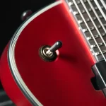 Close-up of a glossy red guitar body with a black toggle switch near the edge. ขายราคาพิเศษ
