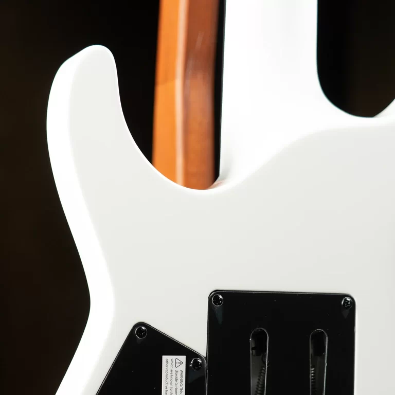 Close-up of a white electric guitar body from the back, showing a natural wood neck and a black tremolo cavity plate. ขายราคาพิเศษ