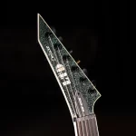 Close-up of a glittery green electric guitar headstock with six tuning pegs and strings against a dark background. ขายราคาพิเศษ