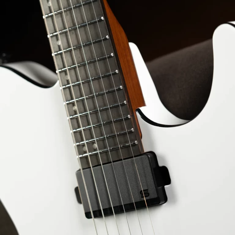 Close-up of a white electric guitar neck, showing metal frets and strings with a black pickup near the body. ขายราคาพิเศษ