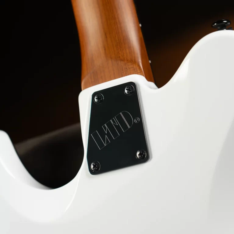 Close-up of the back of a white electric guitar showing the wood neck and a black four-screw neck plate reading 'LMD'. ขายราคาพิเศษ