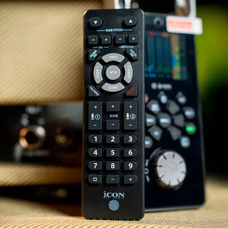 Close-up of a black universal remote with a circular navigation pad and numeric keypad, ICON Pro Audio at the bottom. ขายราคาพิเศษ