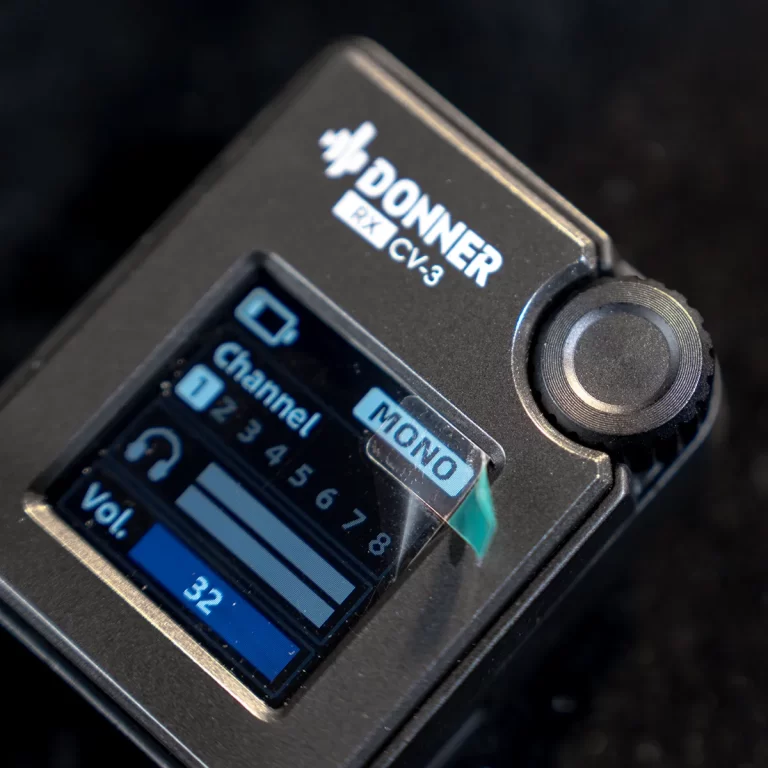 Close-up of a Donner RX-CV3 device showing its small display with 'Channel' options and a 'MONO' button, plus a blue volume bar. ขายราคาพิเศษ