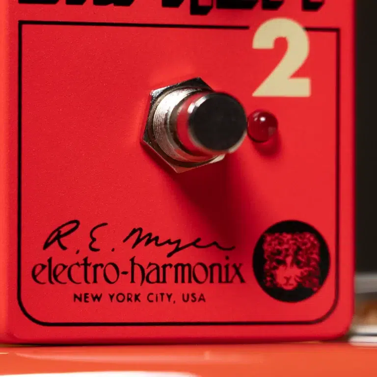 Close-up of a red Electro-Harmonix guitar effects pedal, showing a silver footswitch, a small red LED, and brand text with 'New York City, USA.' ขายราคาพิเศษ