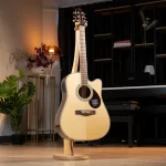 Acoustic guitar on a wooden stand in a cozy room, with a piano, plants, and warm lighting in the background. ลดราคาพิเศษ