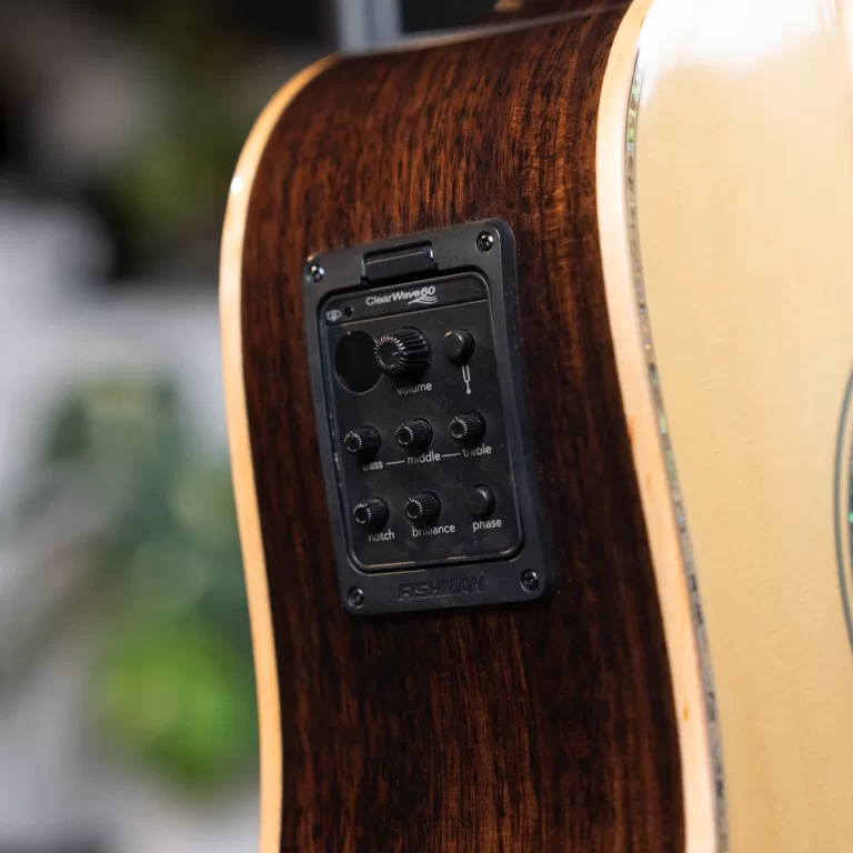 Close-up of a glossy dark wood guitar body showing a built-in Fishman preamp panel with knobs for volume, bass, middle, treble, notch, brilliance, and phase. ขายราคาพิเศษ