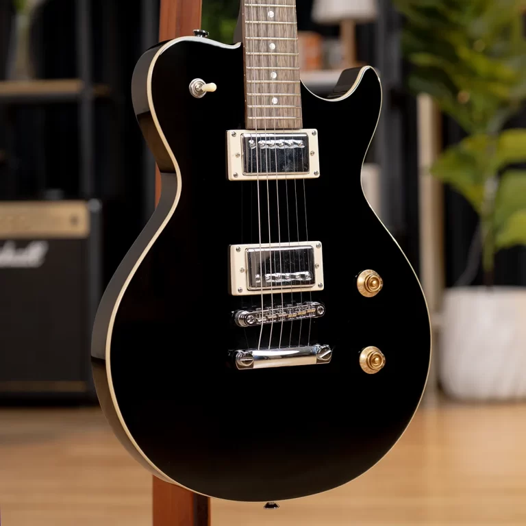 Glossy black electric guitar with gold hardware and cream pickups standing on a wooden guitar stand indoors. ขายราคาพิเศษ