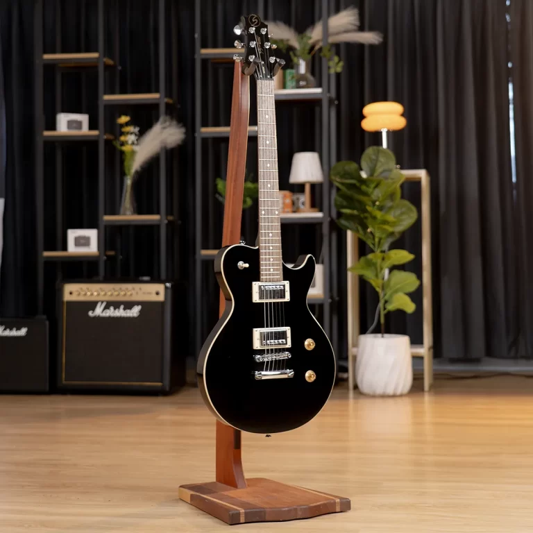 Black electric guitar on a wooden stand in a studio/showroom with amps, shelves, and potted plants in the background. ขายราคาพิเศษ