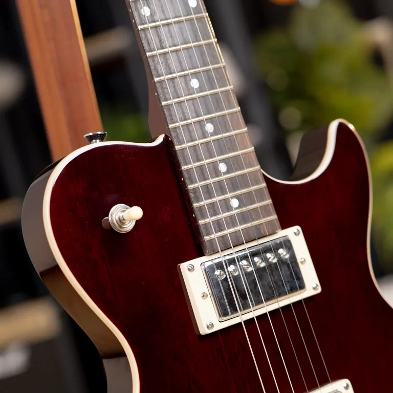 Close-up of a dark red electric guitar body and neck, showing string ferrules and pickup at the bridge. ขายราคาพิเศษ