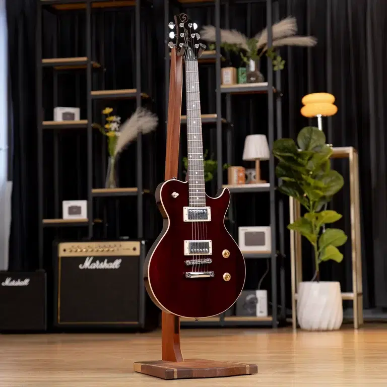 Red solid-body electric guitar on a wooden stand in a music shop with amplifiers and shelves in the background. ขายราคาพิเศษ