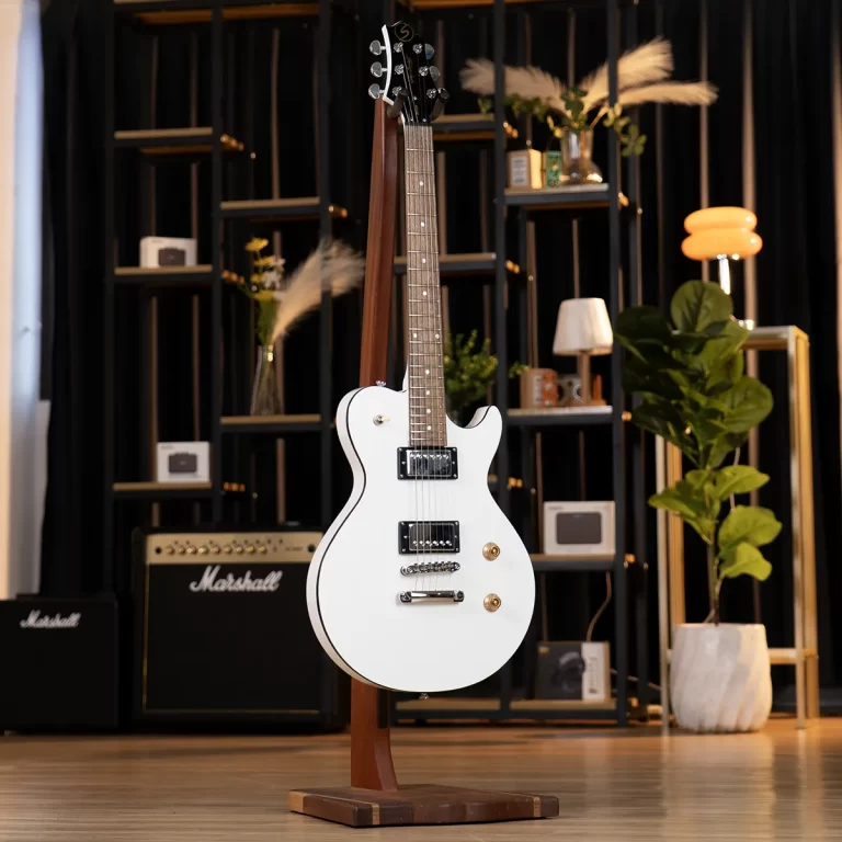 White electric guitar on a wooden stand in a music store, with Marshall amplifiers and shelves in the background. ขายราคาพิเศษ