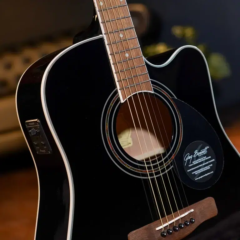 Close-up of a black acoustic guitar showing the body, soundhole, and six strings with a wooden neck and fretboard photographed at an angle. ขายราคาพิเศษ
