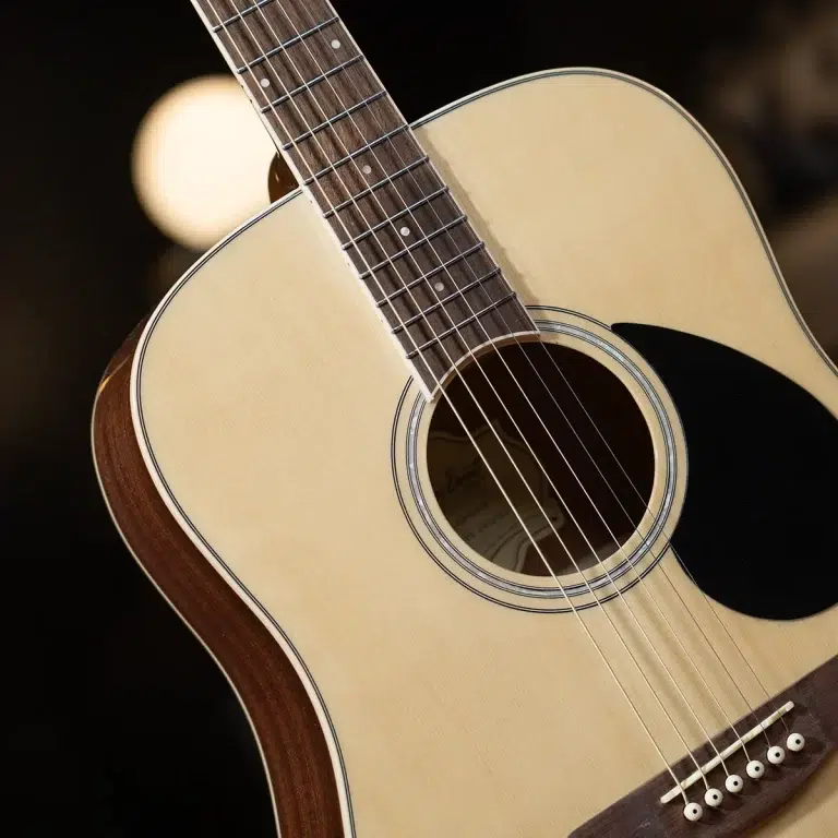 Close-up of an acoustic guitar showing the soundhole, strings, and fretboard on a natural wood top. ขายราคาพิเศษ