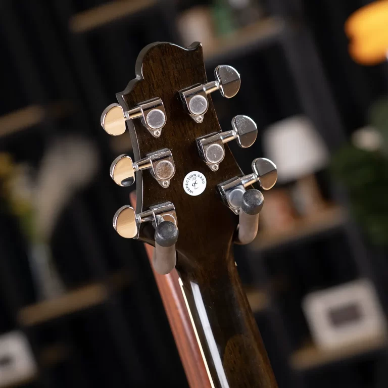 Close-up of a guitar headstock with six chrome tuning pegs on dark wood ขายราคาพิเศษ
